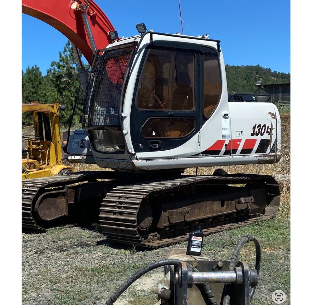 Russco's full-size 30,000 lb excavator with hydraulic thumb attachment on a job site.